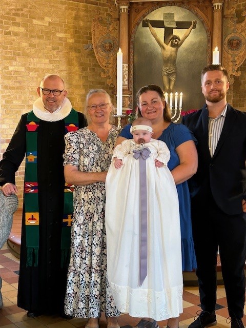 Dåbsbarn med familie og præsten